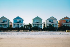 A row of houses on a beach representing snowbird properties in the U.S.