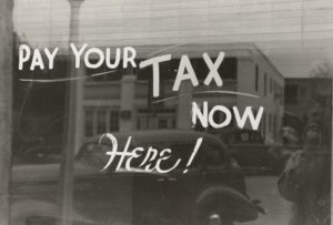 A vintage photo of a window for a business where people could pay income taxes in NYC