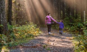 Image of mother and child spending time together in forest.