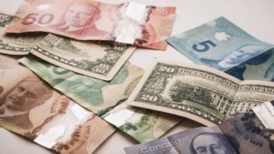 Scattered U.S. and Canadian currency, representing cross-border tax implications of separation and divorce